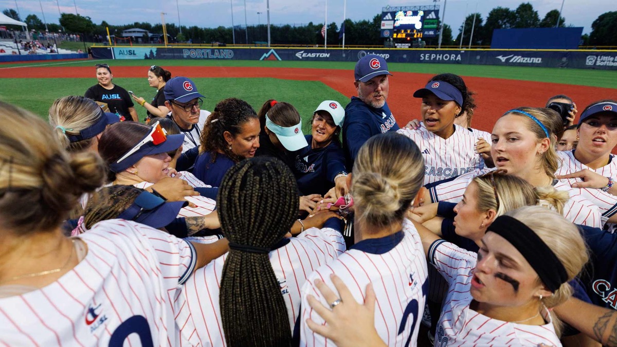 Portland Cascade players and coaches huddle on the field at Hillsboro Ballpark