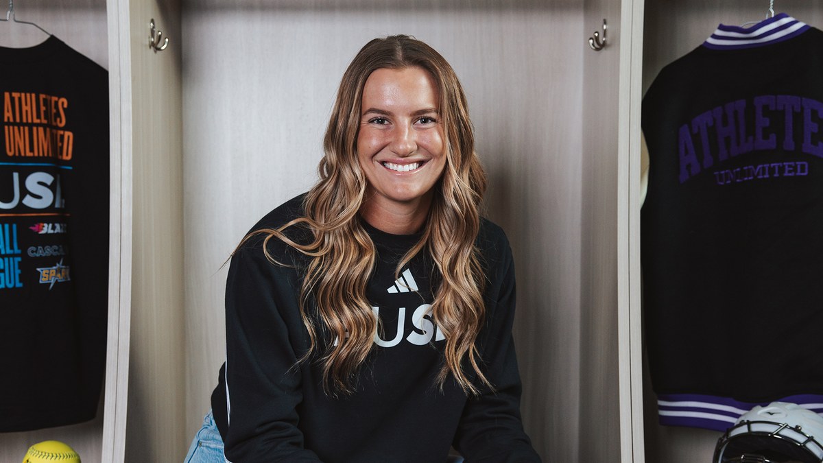 Reese Atwood in a black AUSL sweatshirt at a locker with AUSL gear