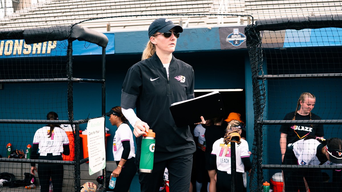 Carolina Blaze head coach Kara Dill walks past the Blaze dugout carrying a binder