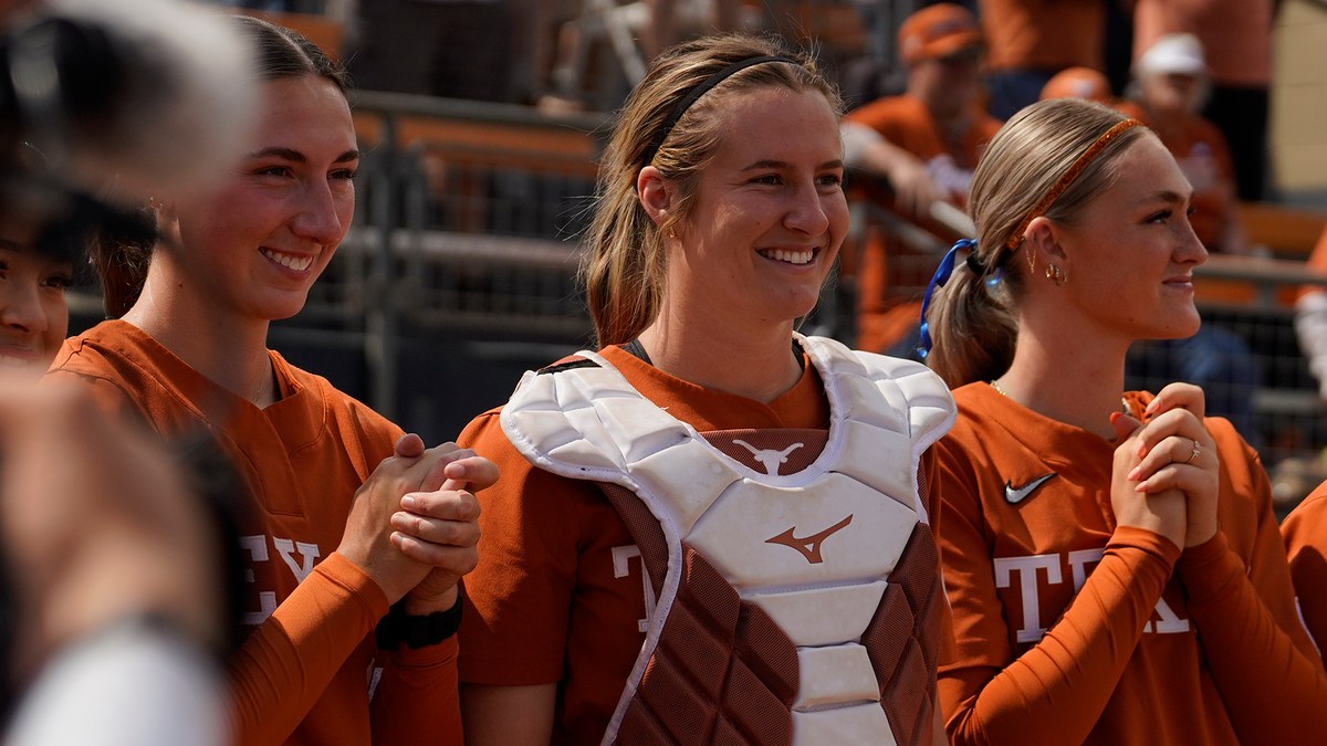 Texas catcher Reese Atwood smiles with teammates in the dugout